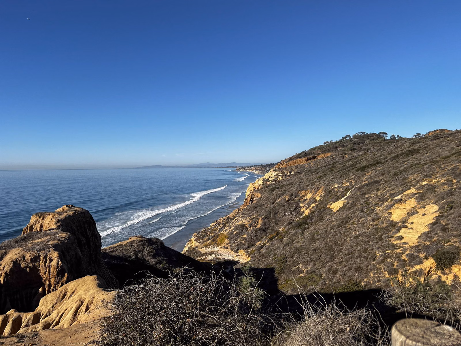 Coastline and eroded sandstone bluffs seen from a clifftop viewpoint